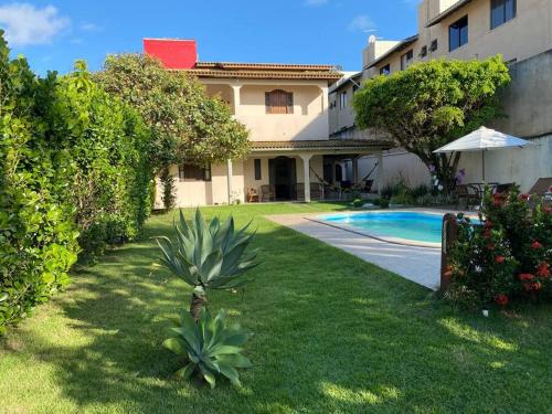 une maison avec une cour et une piscine dans l'établissement Bela casa de praia, arborizada, um paraíso!, à Salvador