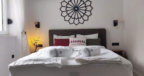 a bed with white sheets and pillows on it at Apartment Fedora Old Town Sarajevo in Sarajevo