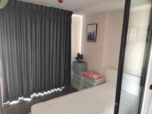 Schlafzimmer mit einem Bett und einem Fenster mit Vorhängen in der Unterkunft Do do in Ban Khlong Samrong