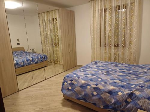 - une chambre avec un lit et un grand miroir dans l'établissement Trilocale Arco d'Augusto con box, à Aoste