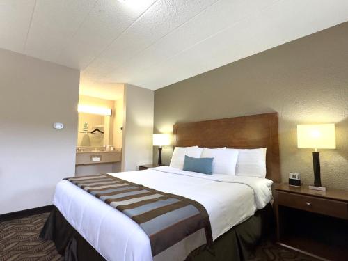 um quarto de hotel com uma cama grande e duas lâmpadas em Super 8 by Wyndham Greensburg em Greensburg