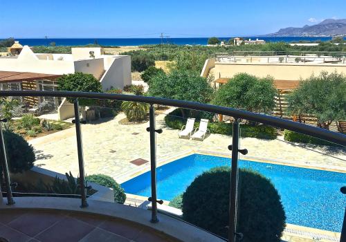 a balcony with a view of a swimming pool at Townhouse 23, Lagada Resort in Makry Gialos