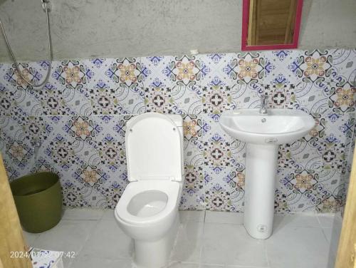 a bathroom with a toilet and a sink at NATUA'S BEACH RESORT in Liminangoon