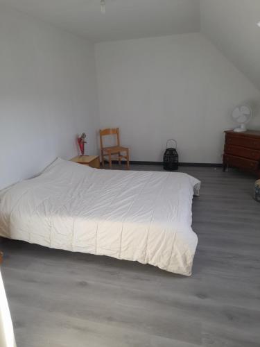 ein Schlafzimmer mit einem Bett mit einer weißen Bettdecke in der Unterkunft Jeannot in Teloché