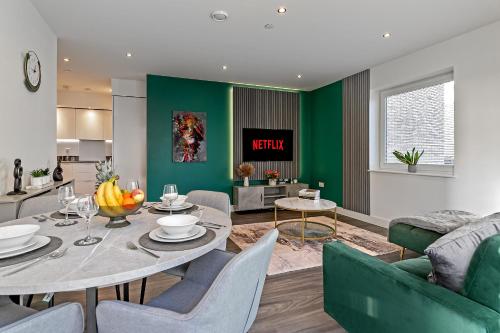 a living room with a table and a green wall at PREMIUM AIRPORT SUITE~Free Parking~LUXURY Condition~BALCONY~FANTASTIC Location Close To Train Station & Town Centre in Luton