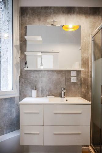 bagno con lavandino bianco e specchio di St Vincent house a Le Havre