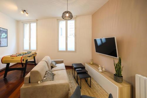 un soggiorno con divano e TV a schermo piatto di St Vincent house a Le Havre