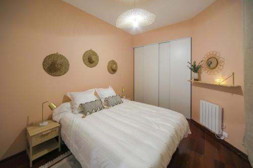 una camera da letto con un grande letto bianco con due cuscini di St Vincent house a Le Havre