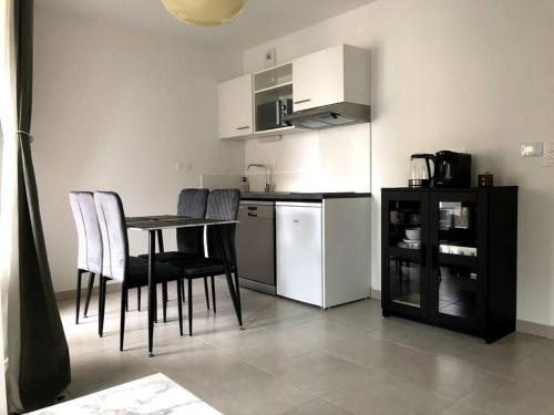 a kitchen with a table and chairs and a refrigerator at Charmant T2 à port Marianne in Montpellier