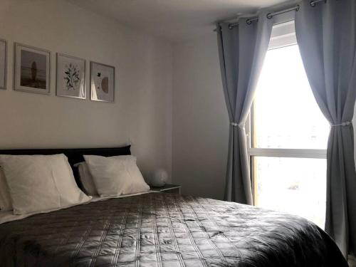 a bedroom with a bed and a large window at Charmant T2 à port Marianne in Montpellier