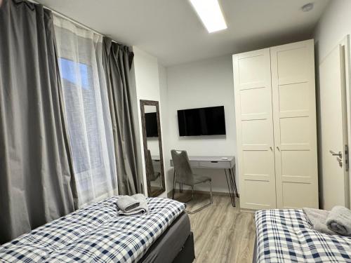a bedroom with two beds and a desk and a television at House-In Apartments - Free Parking - WiFi - Kitchen in Essen