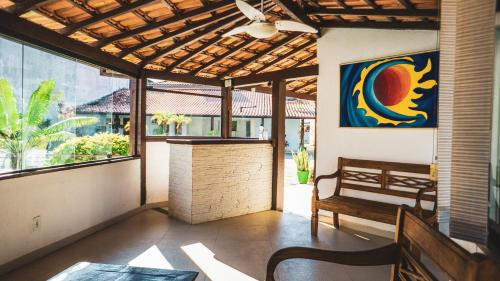 a porch with a bench and a painting on the wall at Pousada El Camenito Geribá Búzios in Búzios