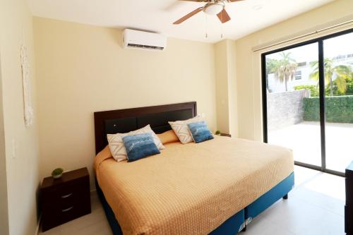 Departamento con terraza privada y alberca a 1 cuadra del Malecón - Flamingo 102 في مازاتلان: غرفة نوم عليها سرير ومخدات زرقاء