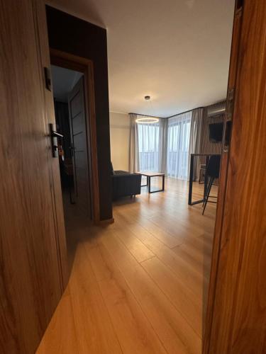 an open door to a living room with a wooden floor at Apartamenty i Pokoje Złote Piaski in Jastrzębia Góra