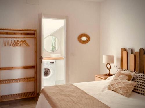een slaapkamer met een bed en een wasmachine bij Click & Guest - Casa Mama Carina B in Agüimes