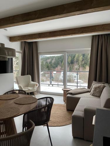 a living room with a couch and a table at Apartament Uzdrowiskowa I Prestige in Szczyrk