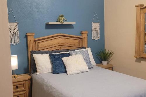 een slaapkamer met een groot bed met blauwe muren bij Casita Bambú cerca del aeropuerto SJD in San José del Cabo