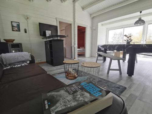 a living room with a couch and a piano at Bienvenue au CHAT LAIT ! in Seilhac