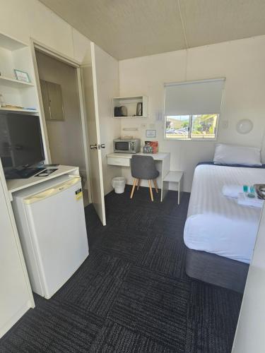 a hotel room with a bed and a desk with a computer at Hive Hotel, Moruya in Moruya
