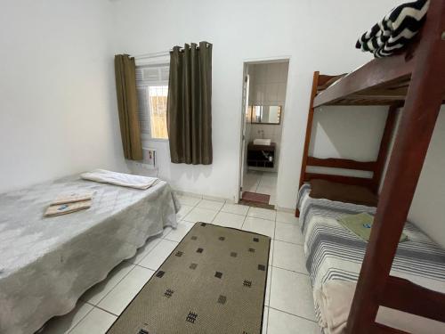 Status Casa Pelinca في كامبوس دوس جويتاكازيس: غرفة نوم بسريرين وسرير بطابقين