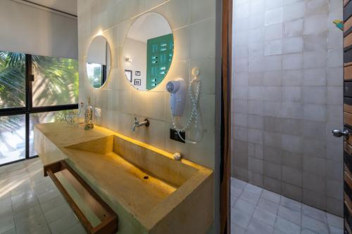 a bathroom with a sink and a mirror at Tropicalito Villa on the Beach in Tulum