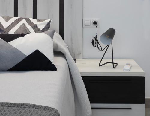 a bedroom with a bed with a lamp on a nightstand at El Rincón de la estación in Ourense