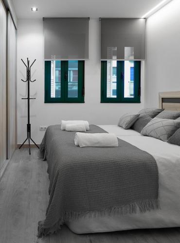 a bedroom with two beds and a cross on the wall at El Rincón de la estación in Ourense