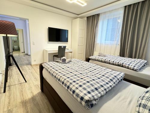 a hotel room with two beds and a flat screen tv at House-In Apartments - Free Parking - WiFi - Kitchen in Essen
