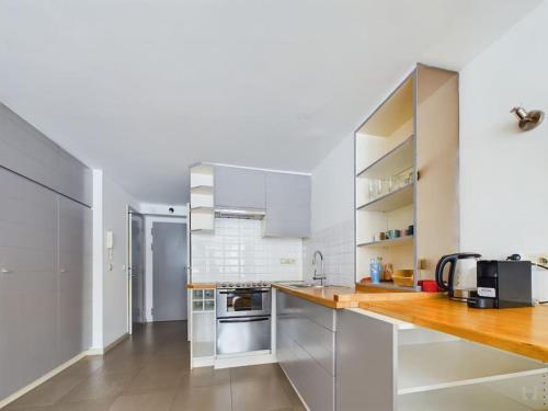a kitchen with white appliances and wooden counter tops at Studio - central, calme et bien placé in Brussels