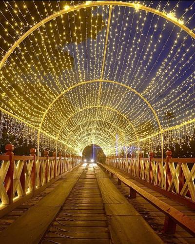 a tunnel covered in lights with a bridge at Pousada Caminho das Cachoeiras Pirenopolis in Pirenópolis