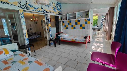 Zimmer mit einem Schlafzimmer mit einem Bett und einem Tisch in der Unterkunft La Maison Mosaic Medoc - Gîtes in Gaillan-en-Médoc