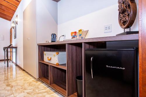 a kitchen with a black refrigerator and a counter at Pousada Cavaleiro dos Pireneus in Pirenópolis