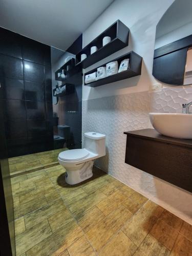 a bathroom with a toilet and a sink at Suite Puembo Bella Stella in Quito