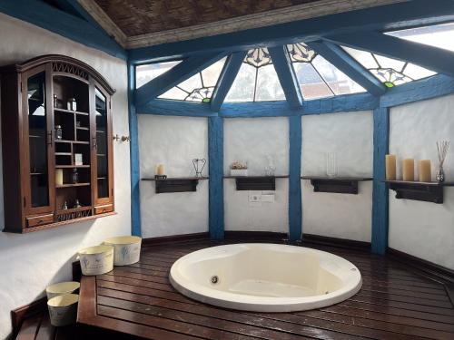 a large bath tub in a room with a window at Historical Mansion in Pampulha in Belo Horizonte