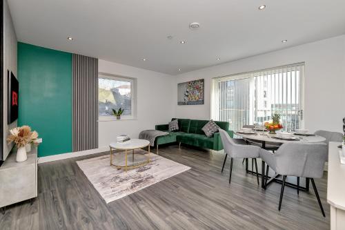a living room with a green couch and a table at PREMIUM AIRPORT SUITE~Free Parking~LUXURY Condition~BALCONY~FANTASTIC Location Close To Train Station & Town Centre in Luton