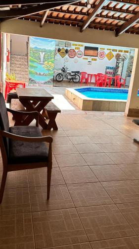 a patio with a table and chairs and a pool at Pousada Caminho das Cachoeiras Pirenopolis in Pirenópolis