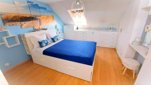 een blauwe en witte slaapkamer met een bed en een stoel bij Appartement Familial pour 6 adultes et 5 enfants à 10 min de Disney in Bailly-Romainvilliers