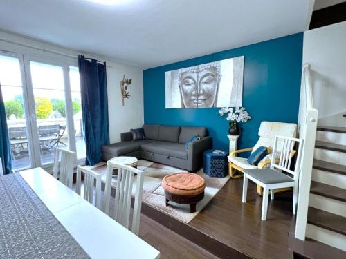 een woonkamer met blauwe muren en een bank en stoelen bij Appartement Familial pour 6 adultes et 5 enfants à 10 min de Disney in Bailly-Romainvilliers