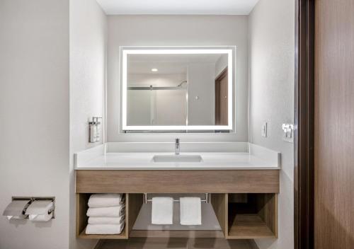 ein Bad mit einem Waschbecken, einem Spiegel und Handtüchern in der Unterkunft Holiday Inn Express San Diego South - National City, an IHG Hotel in National City