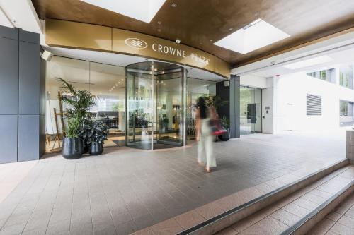 a woman walking in front of a shopping mall at Crowne Plaza Canberra by IHG in Canberra