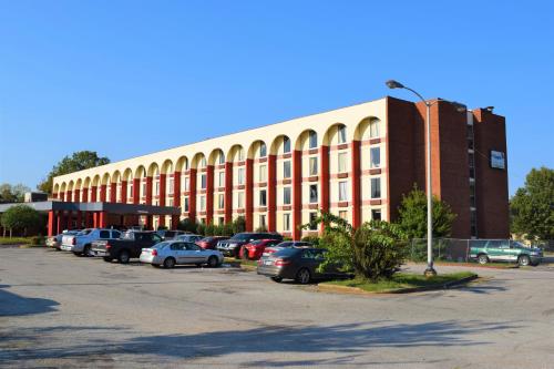 un gran edificio con coches estacionados en un estacionamiento en Economy Hotel Memphis en Memphis