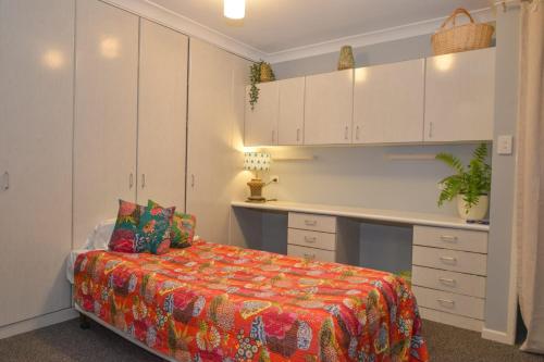 a small bedroom with a bed and a desk at Land Of Lost Treasure in Maleny