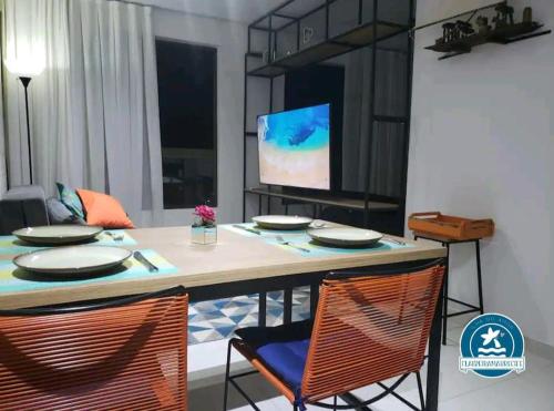 mesa de comedor con 2 sillas y TV en Beira Mar com Café da Manhã flatbeiramarrecife, en Recife