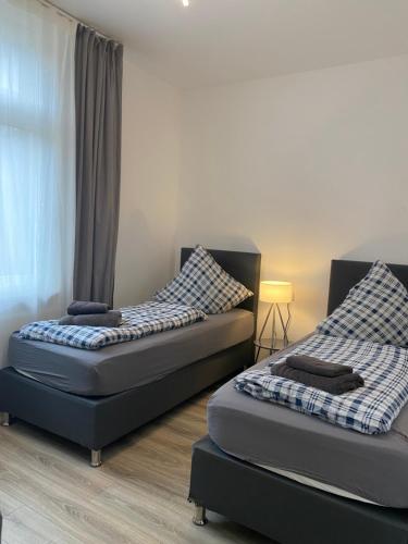 two beds sitting next to each other in a room at House-In Apartments - Free Parking - WiFi - Kitchen in Essen