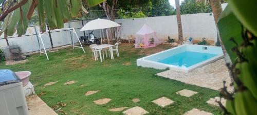 un patio trasero con piscina y sombrilla en Apto Los Blancos, a dos Minuto de los Patos, en Bejuquero