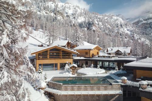 domek narciarski z pokrytą śniegiem górą w obiekcie Kolfuschgerhof Mountain Resort w mieście Colfosco