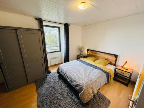 1 dormitorio con cama, ventana y puerta en Maison au calme pour 12 personnes, en La Chapelle-de-Brain