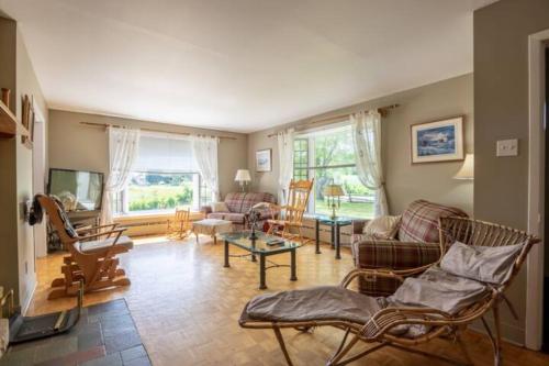 een woonkamer met stoelen, een bank en een tafel bij Les chalets labbé in Saint-François