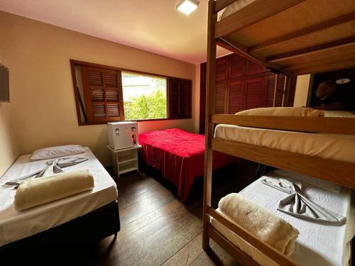 a bedroom with two bunk beds and a window at Village Hostel in Petrópolis