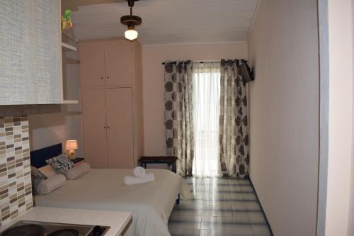um pequeno quarto com uma cama e uma janela em Paradisus Apartments em Barbati